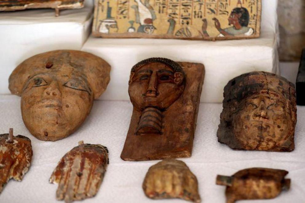 Wooden masks are displayed outside the newly discovered tomb.