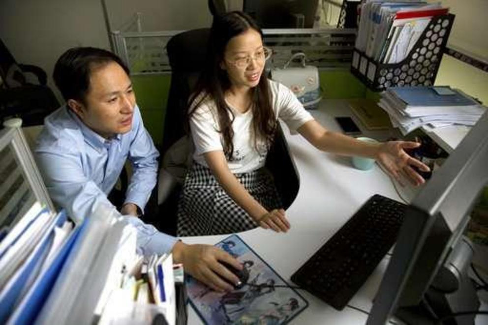 In this Oct. 10, 2018 photo, He Jiankui, left, and Zhou Xiaoqin work a computer at a laboratory in Shenzhen in southern China's Guangdong province. Chinese scientist He claims he helped make world's first genetically edited babies: twin girls whose DNA he