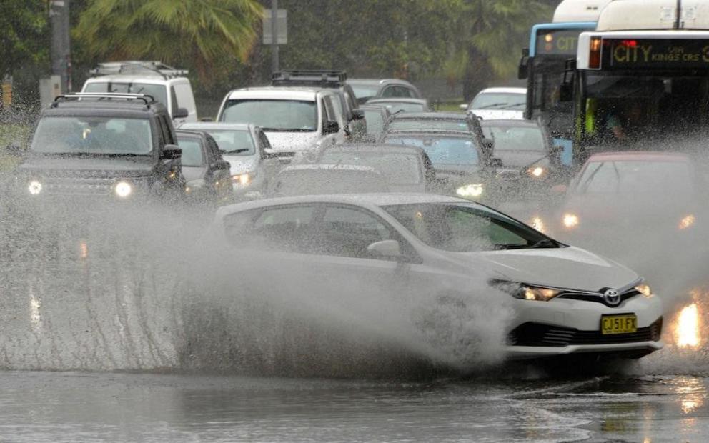 Wet through: motorists were stranded on flooded roads, while flights were cancelled and railway lines closed