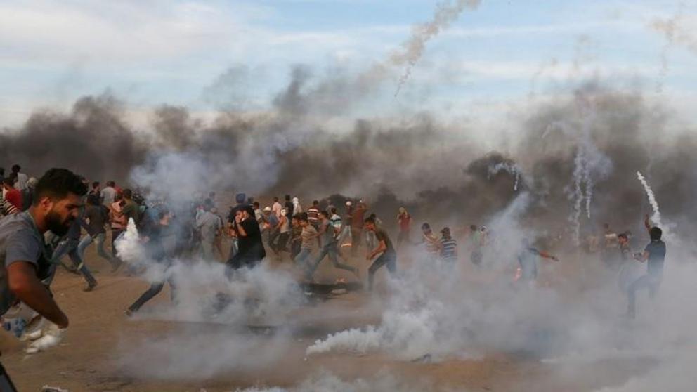 Palestinian protesters in Gaza Strip flee tear gas fired by Israeli troops, October 5, 2018 ©  Reuters / Ibraheem Abu Mustafa 