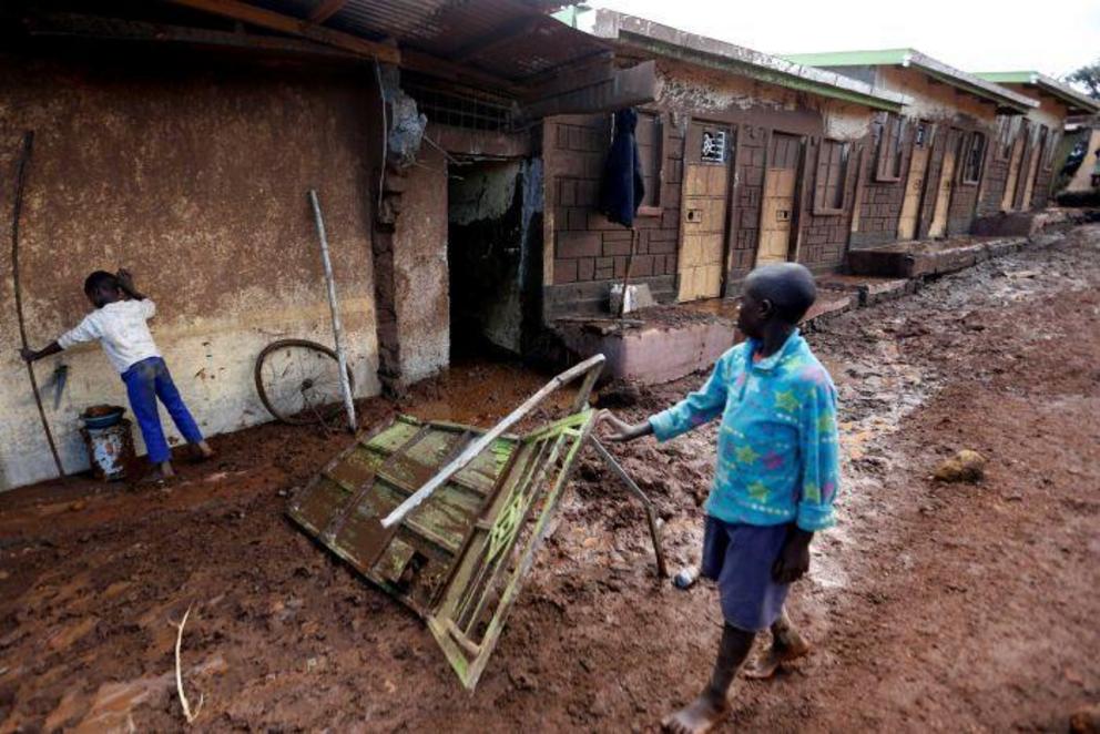 Children look at houses destroyed by flooding in their neighbourhood.