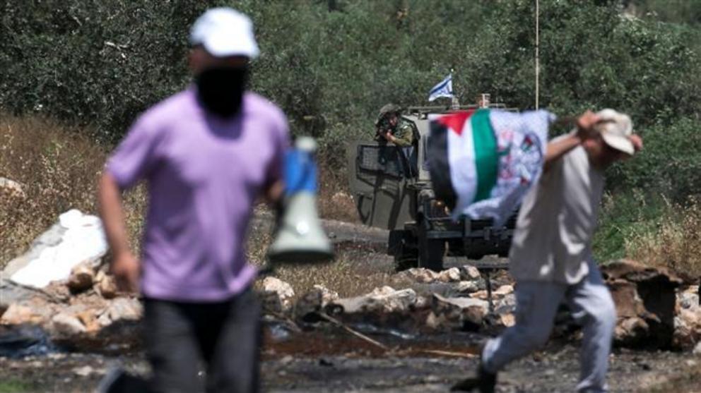 An Israeli soldier takes position as Palestinian protesters clash with Israeli forces during a weekly demonstration against the expropriation of Palestinian land by Israel in the village of Kfar Qaddum, near Nablus in the occupied West Bank, on May 18, 20