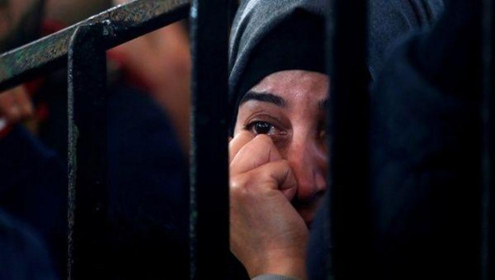 A Palestinian woman in the southern Gaza Strip waits for a travel permit to cross into Egypt through the Rafah border crossing after it was opened by Egyptian authorities for humanitarian cases. | Photo: Reuters 
