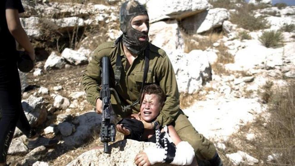 The file photo shows an Israeli soldier detaining a 12-year-old Palestinian boy in the West Bank.