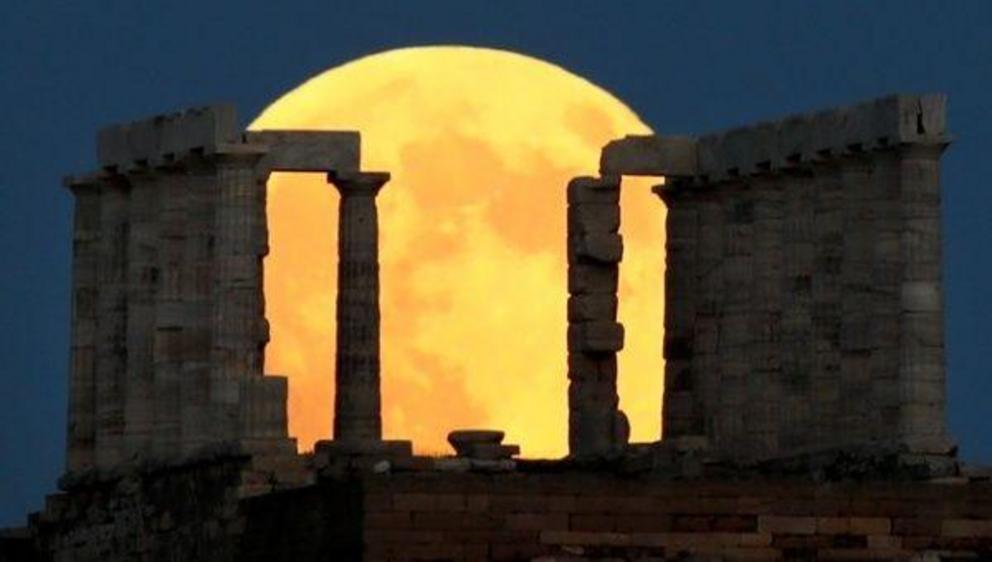 A full moon rises behind the Temple of Poseidon before a lunar eclipse in Cape Sounion, near Athens, Greece, July 27, 2018. | Photo: Reuters