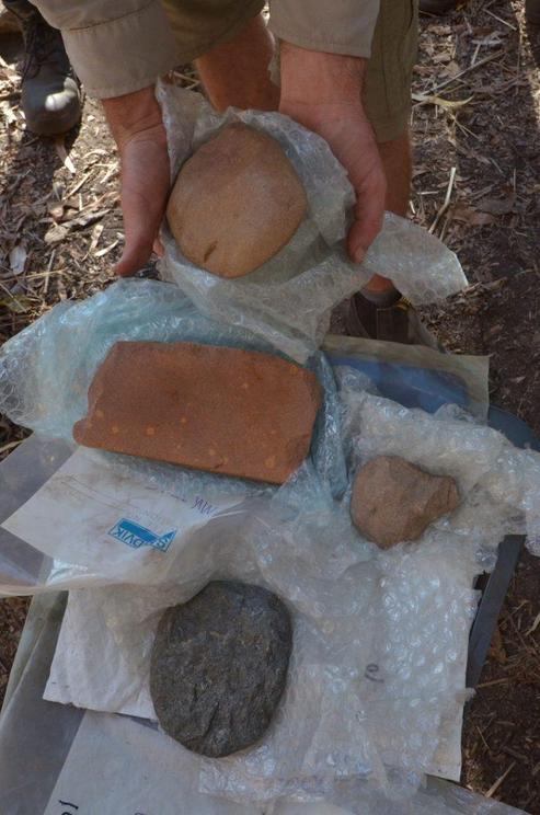 Three axes from different layers of the site and a rectangular sharpening stone from the 65,000-year level
