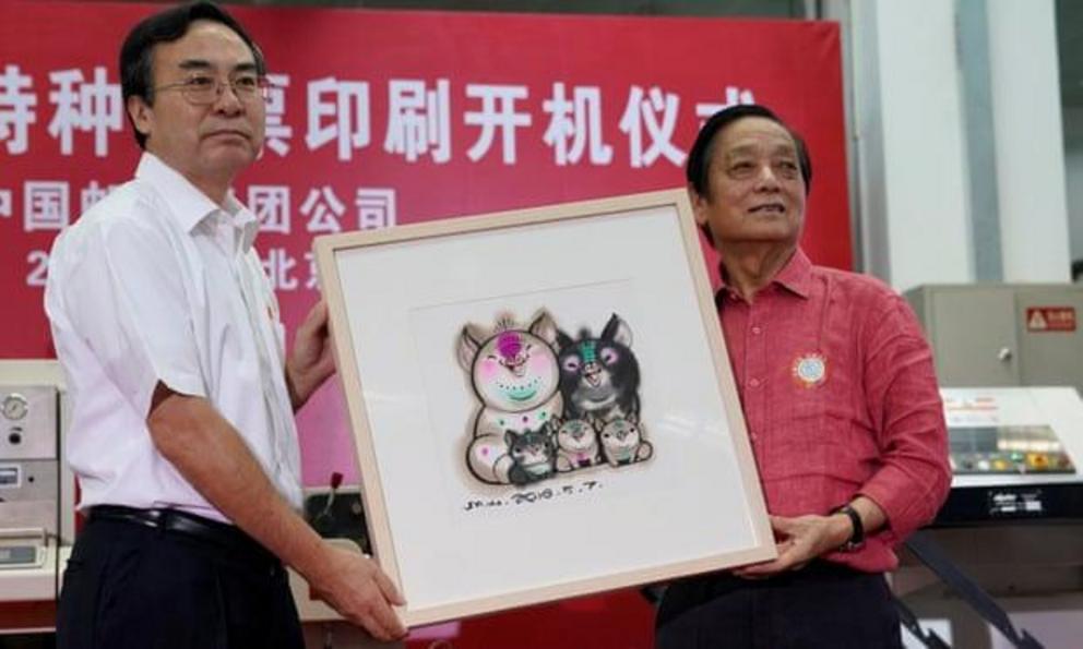 Designer Han Meilin presents his design manuscript for a Year of the Pig stamp to Liu Aili, president of China Post.