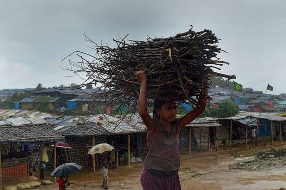 A child carries wood as rain falls at Jamtoli, another of the refugee camps in Cox’s Bazar.