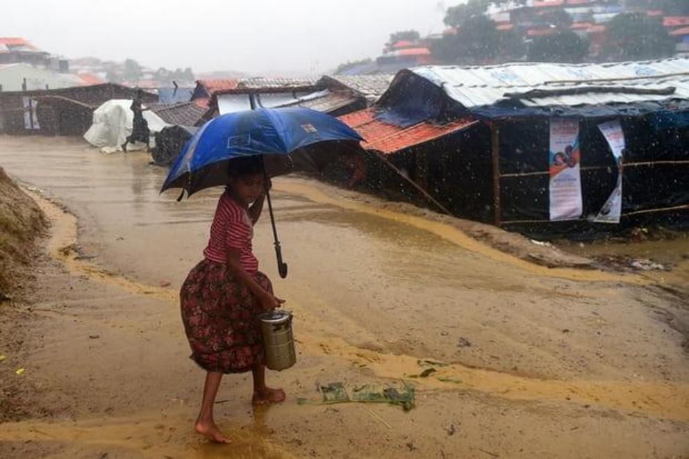 A girl makes her way home after collecting relief aid during a rain storm at Balukhali refugee camp.