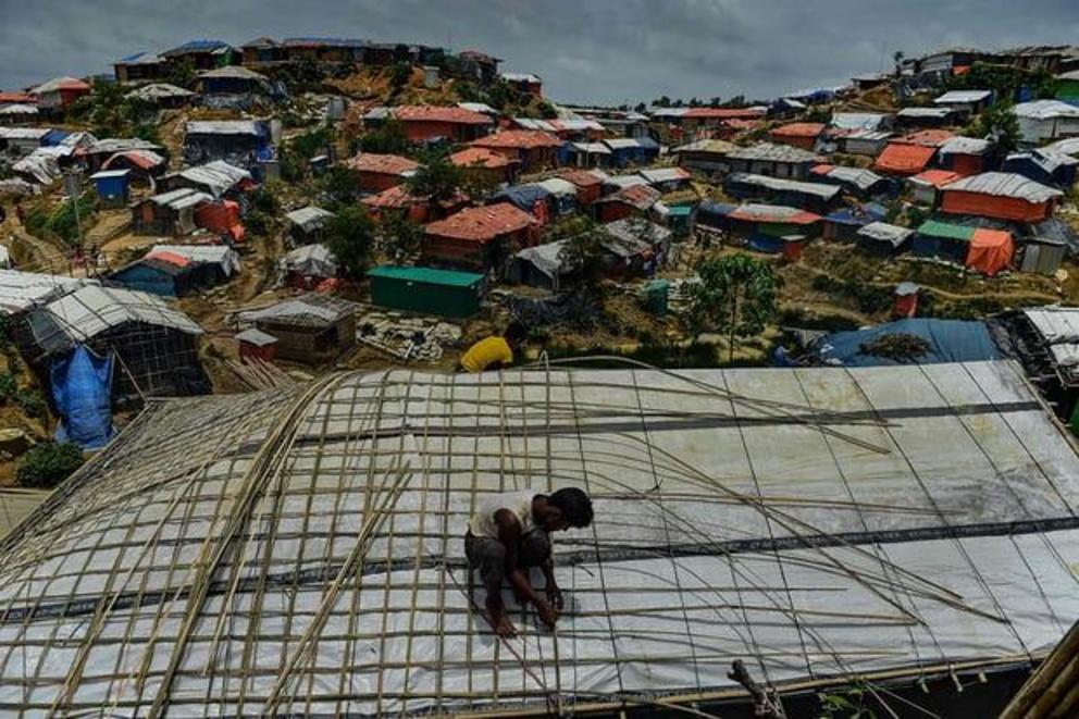 A Rohingya refugee uses bamboo to fix his roof during the monsoon season at Balukhali refugee camp, neighbouring the Kutupalong site, in Cox’s Bazar, Bangladesh.