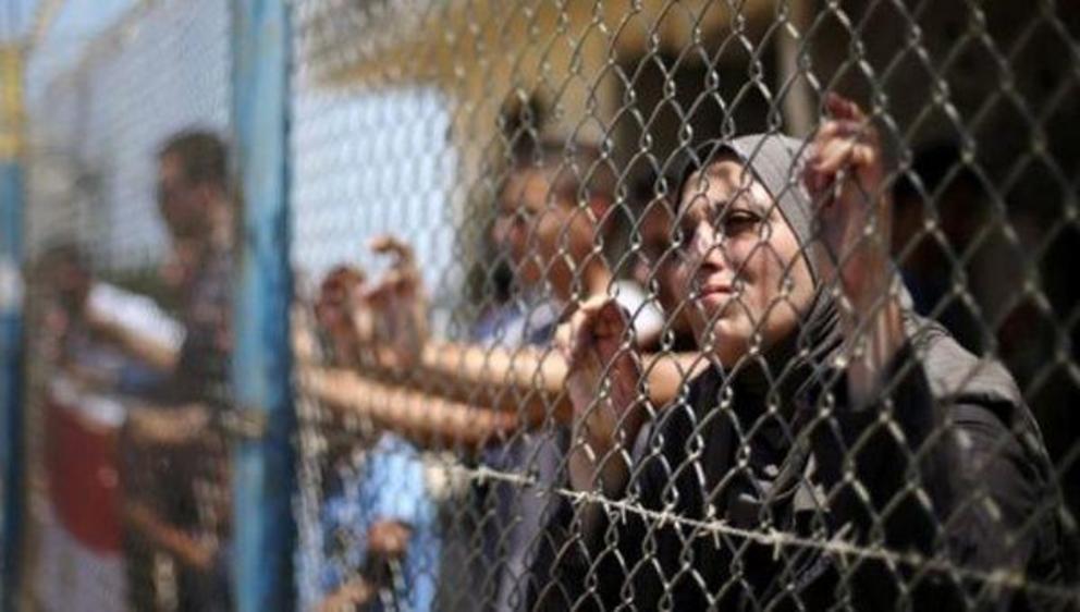 Palestinians gather in front of the gate of Rafah border crossing between Egypt and Gaza during a protest against the blockade calling for reopening of the crossing. | Photo: Reuters
