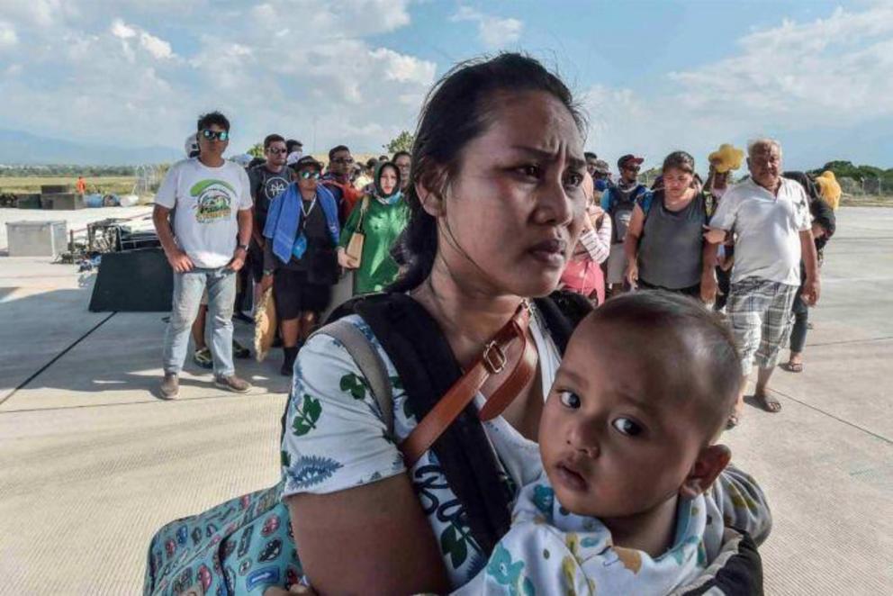 People injured or affected by the earthquake and tsunami wait to be evacuated on an air force plane in Palu.