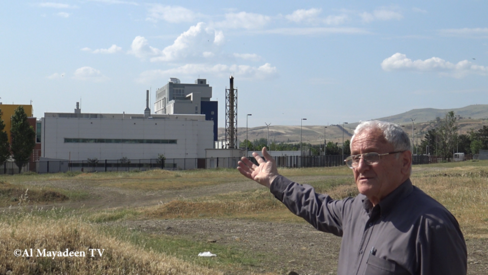 Albert Nurbekyan who lives about 300 m from the laboratory shows the four chimneys from the Lugar Center which release smoke at night.