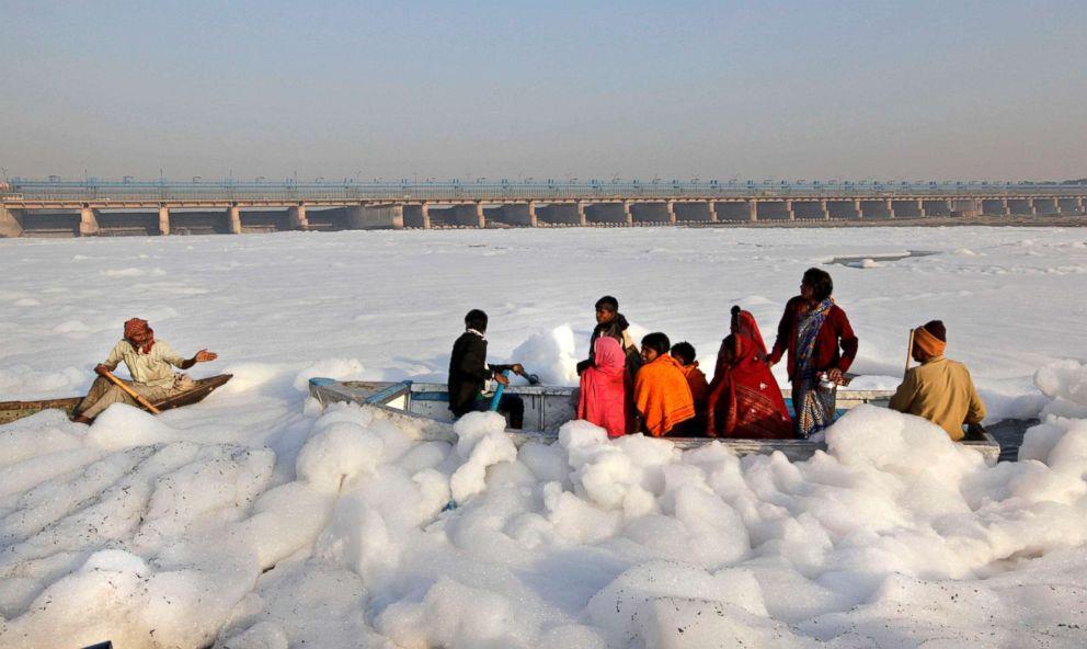 Hindu devotees cross the Yamuna river, surrounded by industrial effluent, on a boat during Karthik Purnima in Delhi, India, Nov. 28, 2012. 