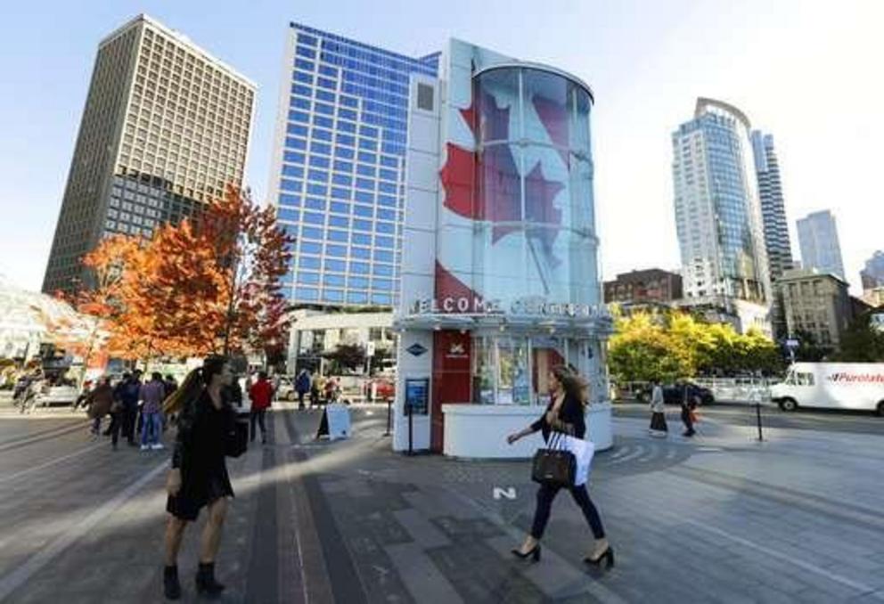In this Sept. 25, 2018 photo, visitors walk near Canada Place, a tourism and convention center in Vancouver, British Columbia. On Oct. 17, 2018, Canada will become the second and largest country with a legal national marijuana marketplace, a profound soci