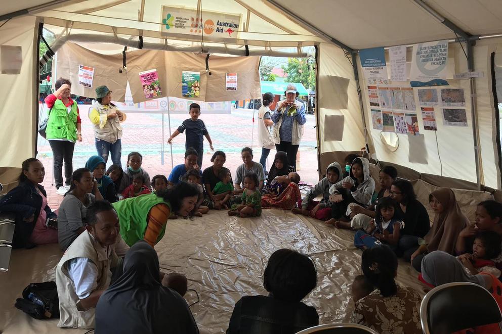 Displaced mothers and their children gather in a UNFPA-supported reproductive health tent.