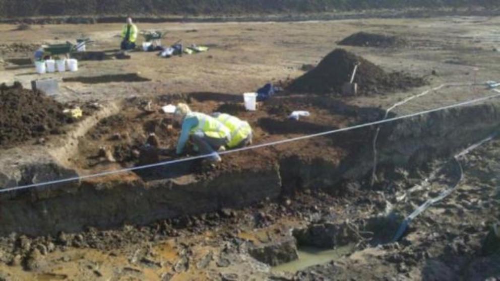 Archaeologists at work in the waterlogged pit.