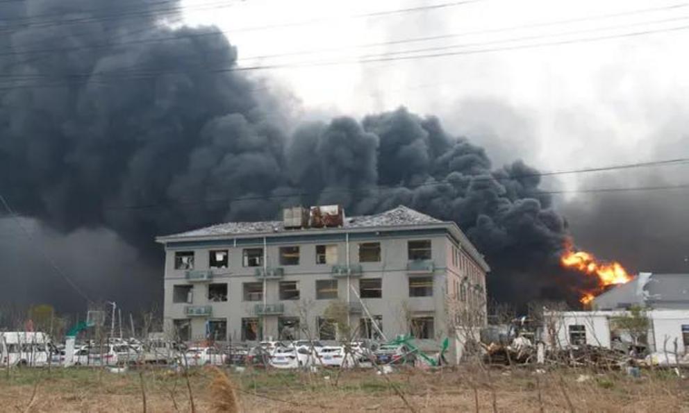 Smoke billows from fire behind a damaged building following an explosion at the pesticide plant in Yancheng.