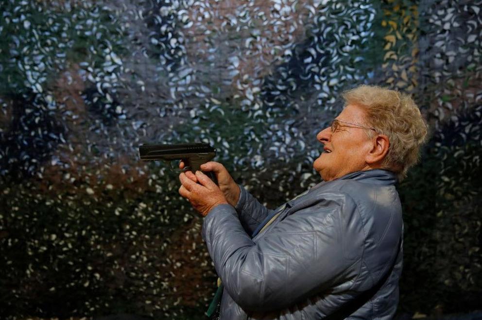 A visitor holds and tries a handgun during an Arms Trade Fair in Lucerne.