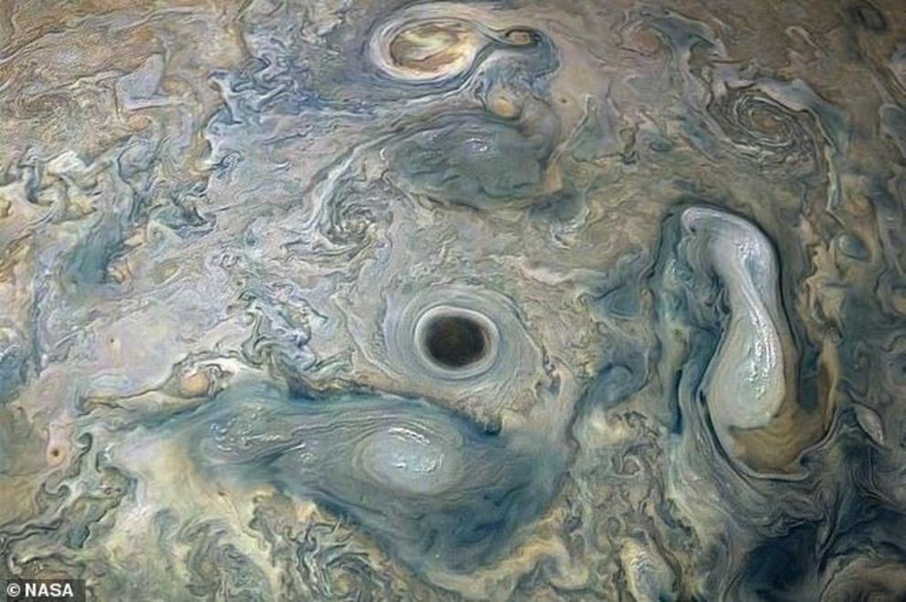 NASA's Juno spacecraft has captured a stunning image of Jupiter, with an 'intensely dark vortex' swirling across the surface. The craft snapped the image during its 20th flyby of the planet on May 29th when Juno was about 9,200 miles from the planet's clo