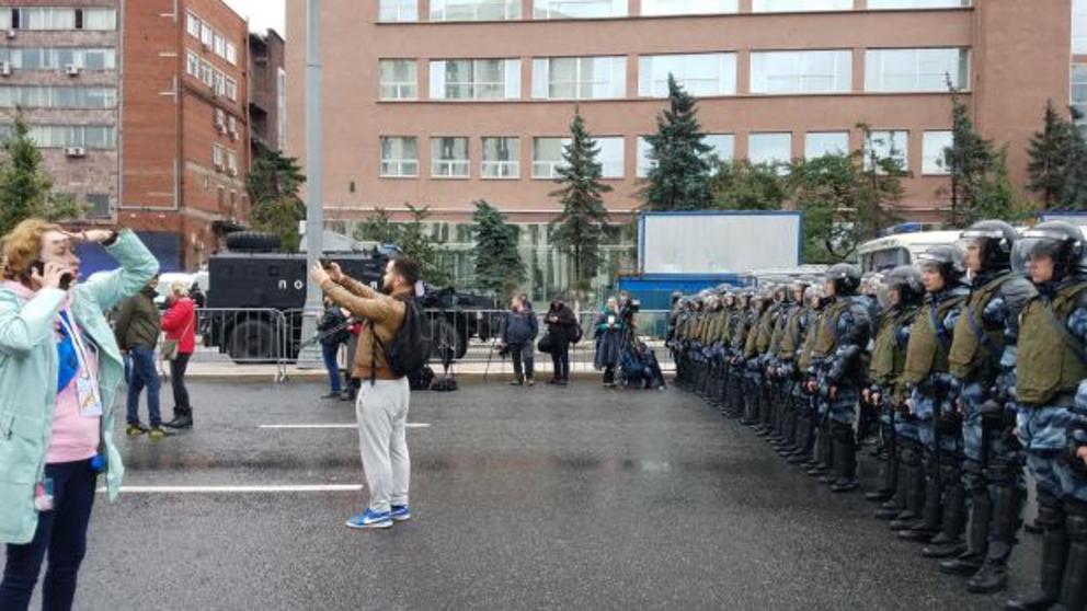 *Photo by Eva Bartlett. Journalist taking selfie in front of Russian police. Many journalists at the protest had a visible fixation with framing their photos with police. The intent seems clear enough to me. Police, by the way, did not react to this nor t