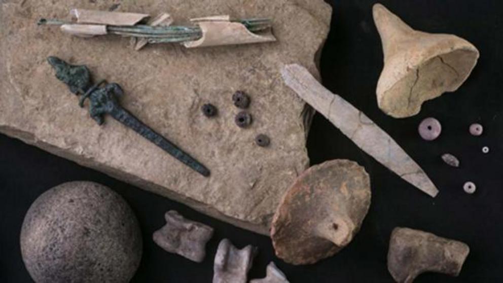 Items found at Zincirli include bronze needles stored in a bone case (top left), a bronze figurine of a goddess (left), and animal knucklebones often used as dice (bottom).