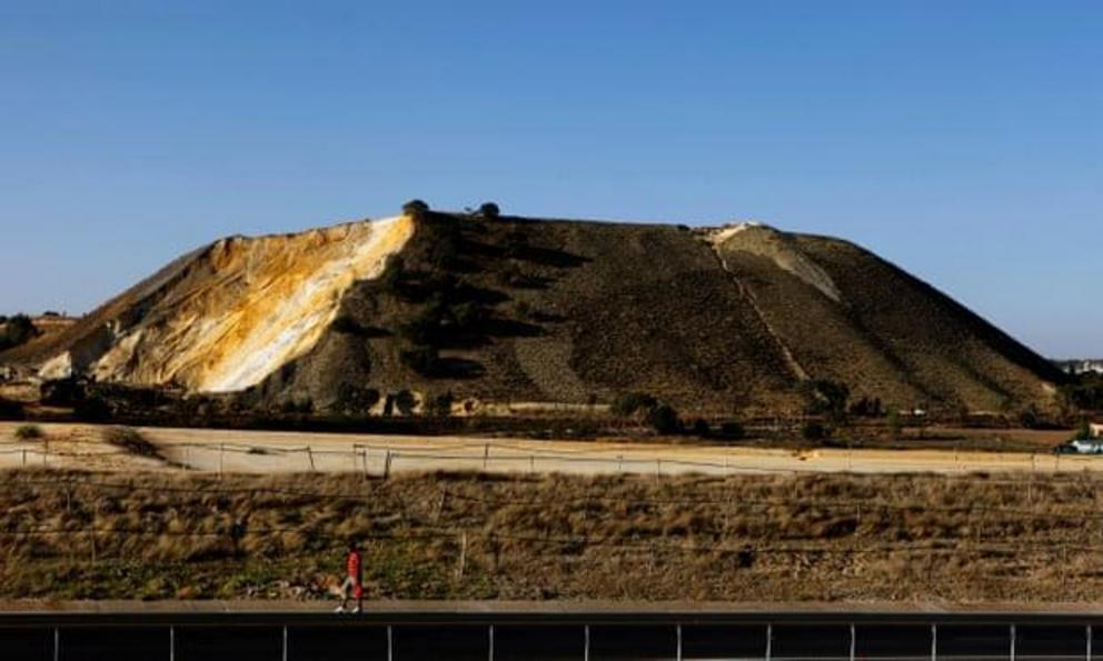 A man walks in front of a goldmine dump outside Soweto