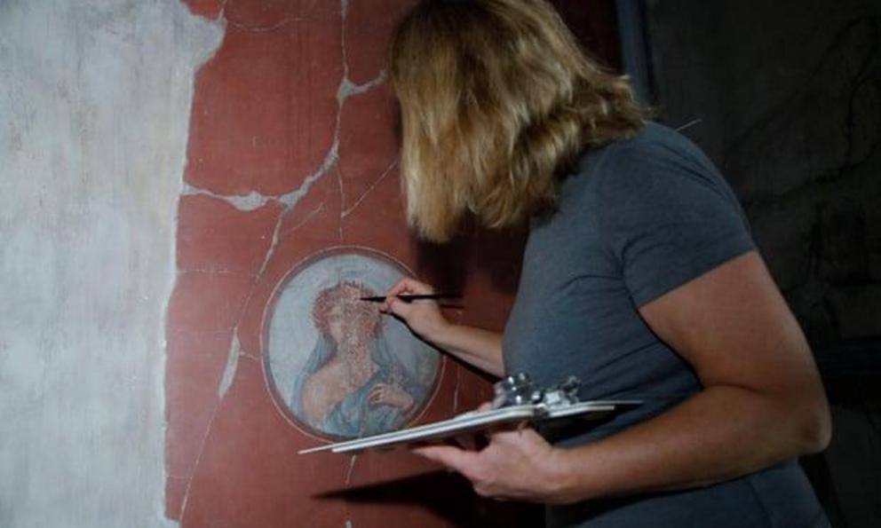 A restorer works on a fresco inside the House of the Bicentenary.