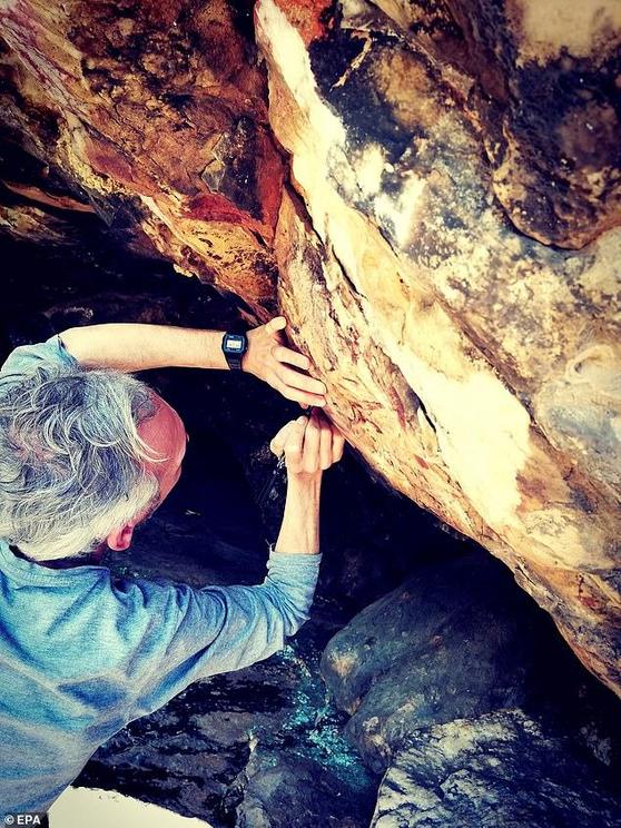 Spanish expert and researcher Agustin Palomo inspects a 5,000 year-old cave painting discovered in Alburquerque, Extremadura, Spain