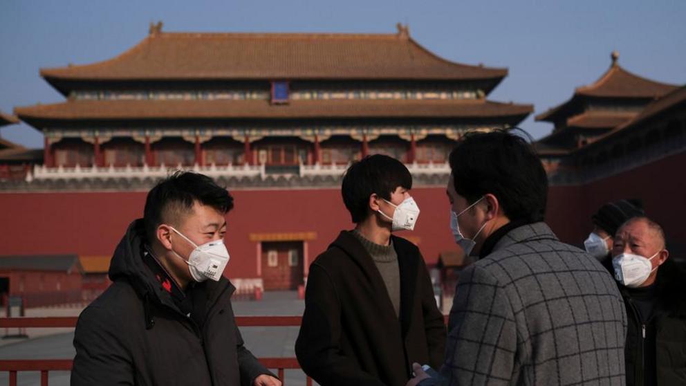 People wearing protective masks stand outside the main entrance of the Forbidden City in Beijing © REUTERS/Carlos Garcia Rawlins 