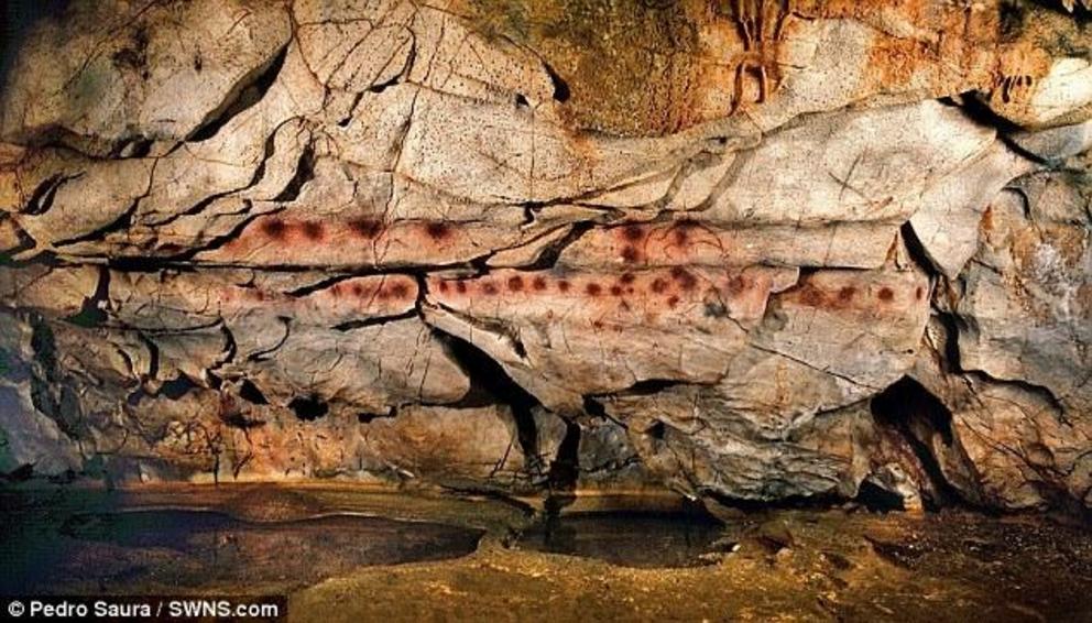 Record-breaker: The 'Panel of Hands' artwork in the El Castillo cave in northern Spain. Made by blowing or spitting paint onto the wall, scientists have estimated the art to be at least 40,800 years old