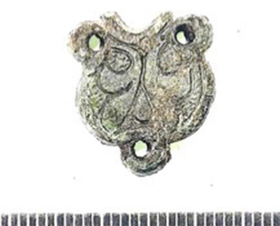 Left; A medieval pot partially reconstructed from fragments excavated from within the Ravne3 Tunnels. Right; A bronze pendant connector with Romanized Celtic motif recovered from the Ravne3 Tunnels