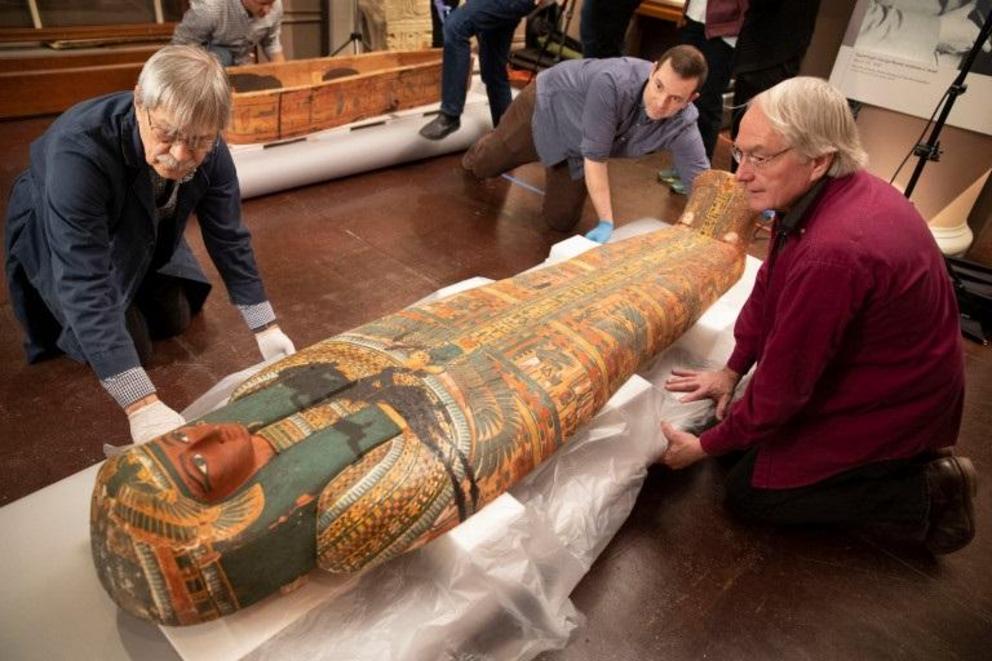 Dennis Piechota (from left), Adam Middleton, and Joe Green work on the coffin of Ankh-Khonsu with a team at the Semitic Museum.