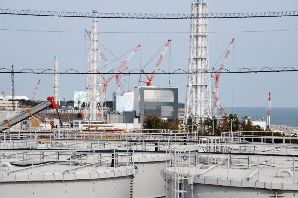 “Water tanks holding contaminated water in front of the reactor buildings at Fukushima Daiichi.”