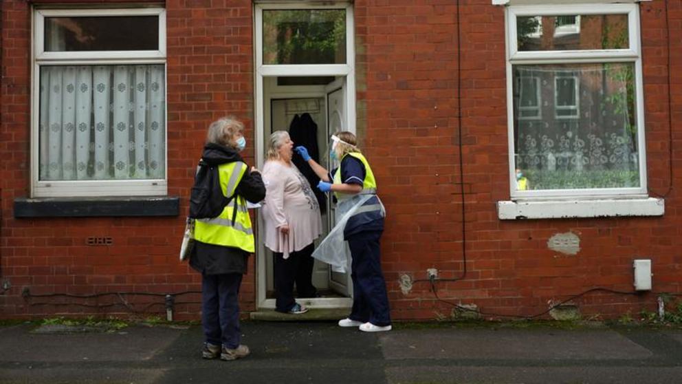 FILE PHOTO A member of the community swabbing team carries out a doorstep COVID-19 test following the outbreak of the coronavirus disease in Chadderton, Britain, October 1, 2020. © REUTERS/Phil Noble 