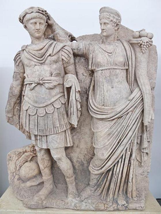 Nero and Agrippina. Agrippina crowns her young son Nero with a laurel wreath. She carries a cornucopia, symbol of fortune and plenty, and he wears the armor and cloak of a Roman commander, with a helmet on the ground at his feet. The scene refers to Nero'