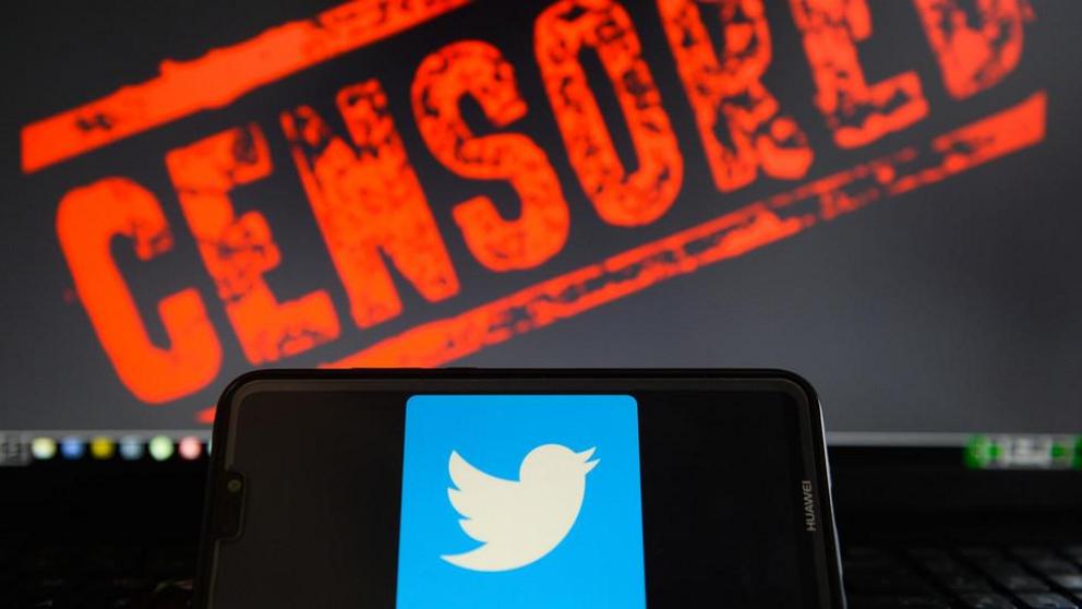 In this photo illustration, the Twitter logo is seen on a Huawei smartphone with the word censored on a laptop monitor ©  Getty Images / Omar Marques / SOPA Images / LightRocket