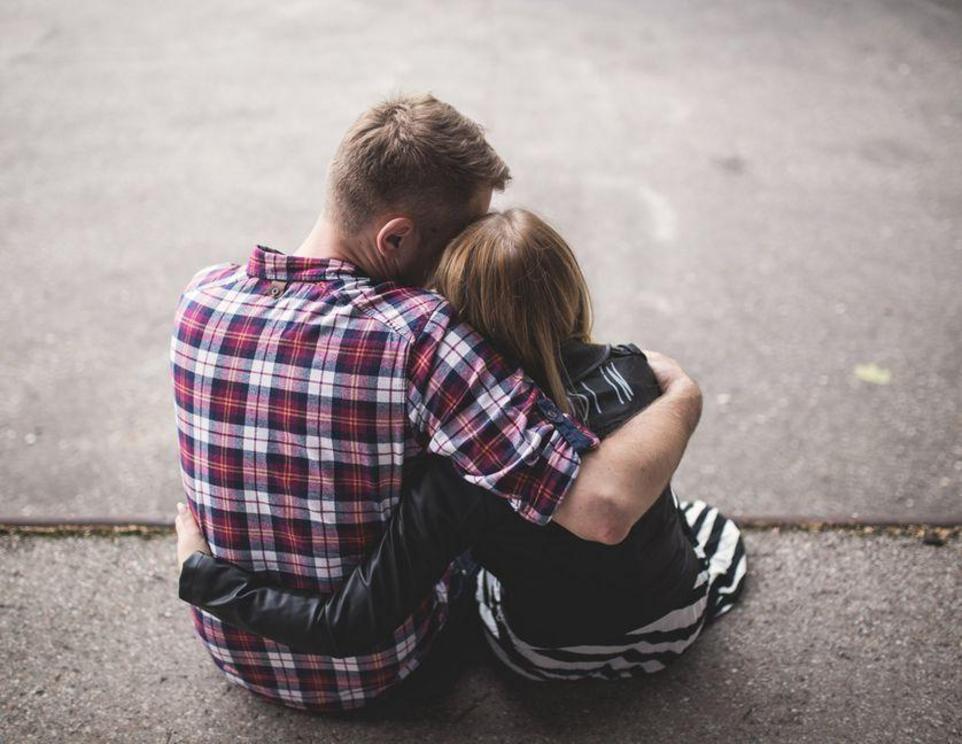 A man and a woman hug each other while sitting down