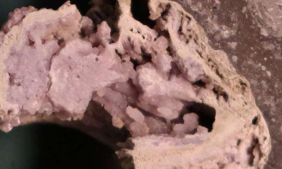 Close-up view of hydrothermal minerals (silica and feldspar) in impact melt rock.