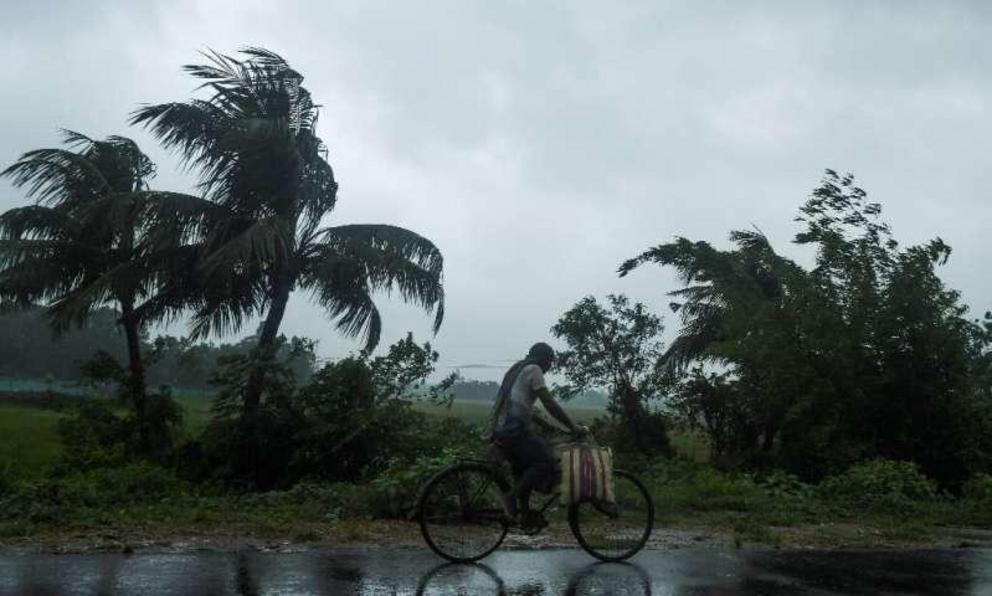 A man rides a bicycle under the rain ahead of the expected landfall of Cyclone Amphan in Midnapore, West Bengal, on May 20, 2020