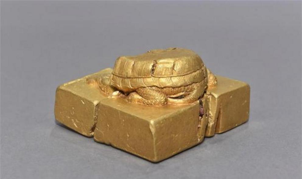 The golden seal pictured showing the tortoise shaped knob, which was found at what is believed to be a Ming battlefield site.