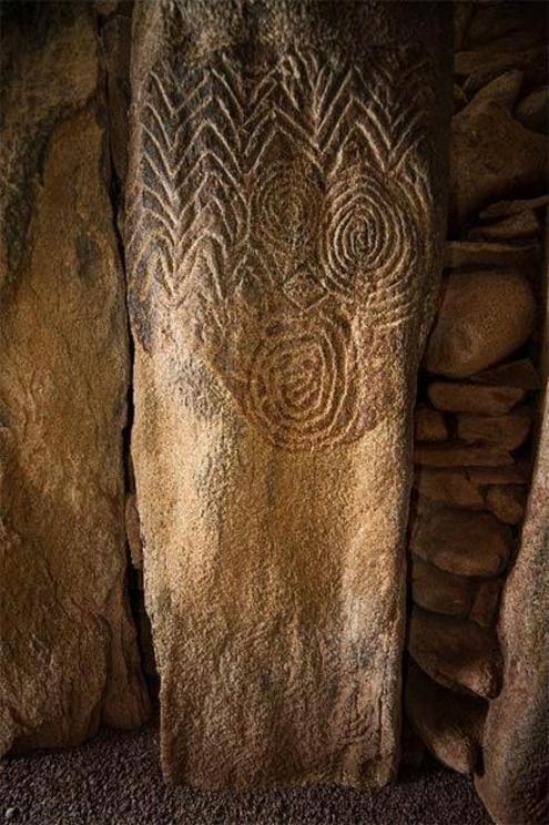 Elaborate decorations carved into a stone inside the chamber of Newgrange, one of the Irish megalith monuments.