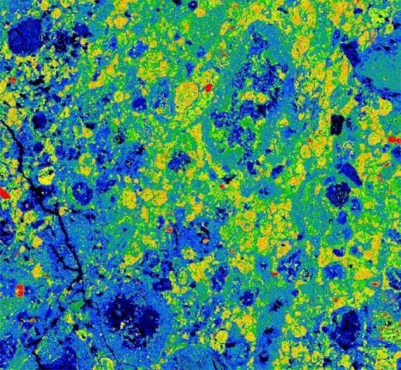This colorful image is a composite element map showing the distribution of different minerals at the microscopic scale in a fragment of the Aguas Zarcas meteorite. Orange-yellow colors show the distribution of a mineral called tochilinite, deep-blue color