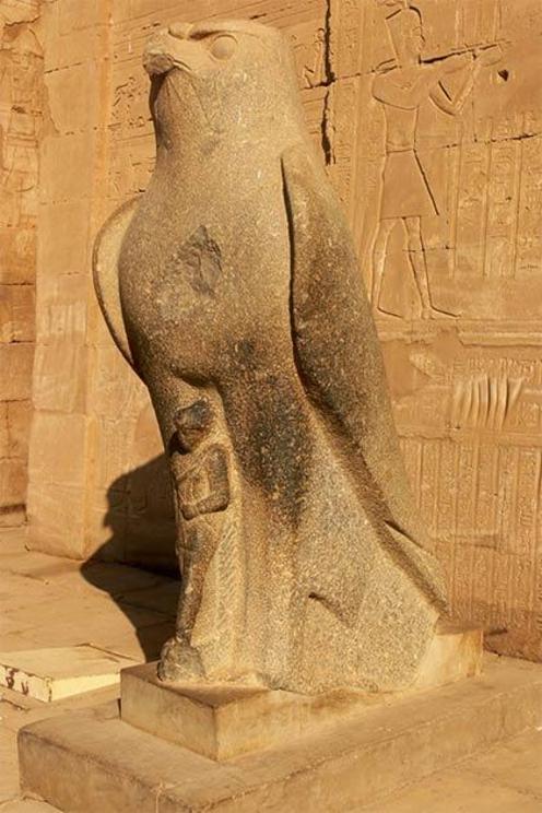 Closeup of the god Horus statue in front of the pylon temple entranceway