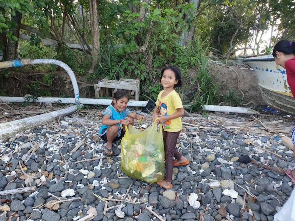 Children clean the beach at Labuhan Amuk Bay as part of fisherman Mangku Latra’s environmental education program.