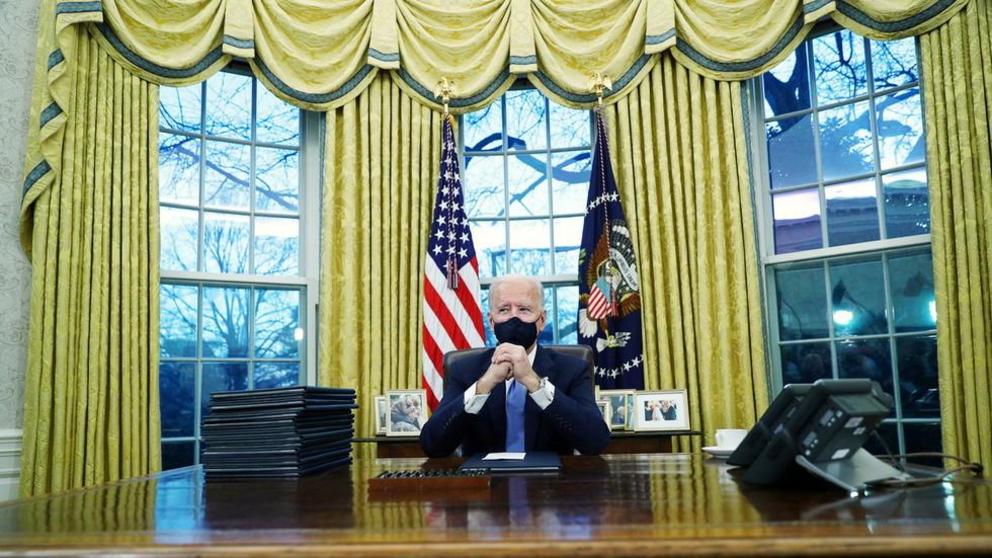 US President Joe Biden signs executive orders in the Oval Office of the White House in Washington, US, January 20, 2021. ©  Reuters / Tom Brenner
