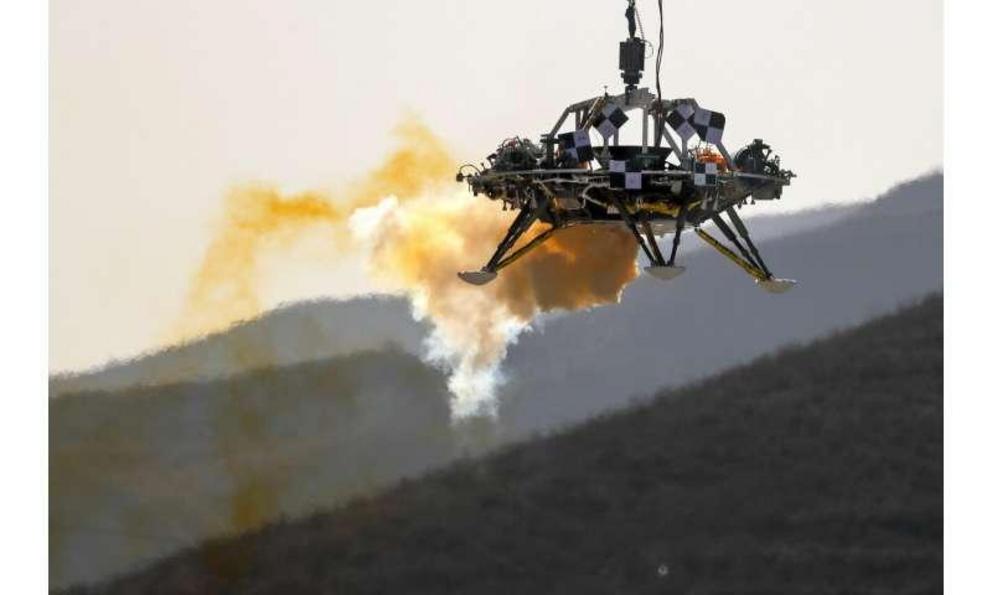 In this Thursday, Nov. 14, 2019 file photo, a lander is lifted during a test of hovering, obstacle avoidance and deceleration capabilities of a Mars lander at a facility in Huailai in China's Hebei province. China's orbiter-rover combo, Tianwen-1, is sche