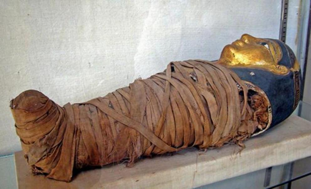 Mummy of a child with a gilded face mask. Alexandria, Egypt.