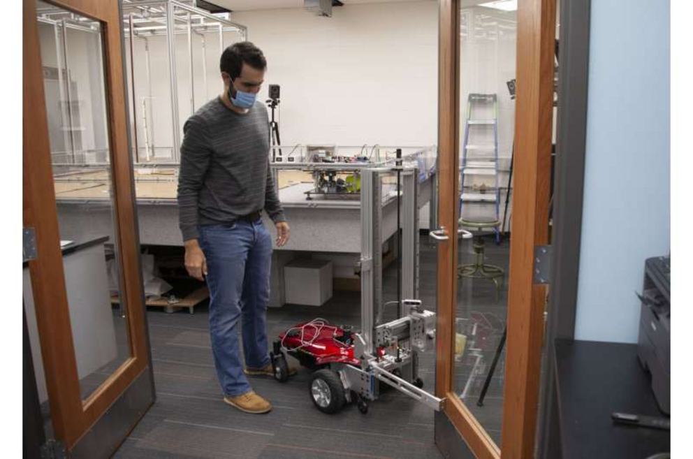 UC engineering student Sam King demonstrates how the autonomous robot will work once complete. Translating the successful AI simulation to a real-world robot could take months of development.