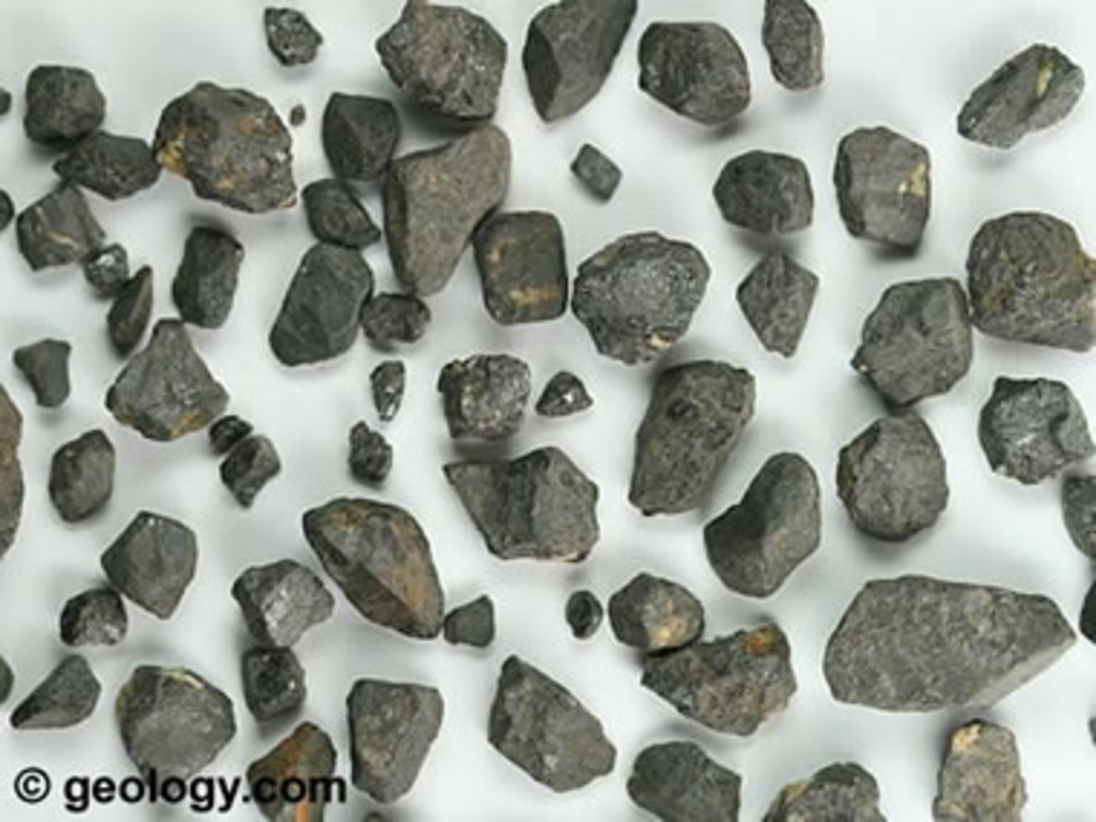 Particles of cassiterite from a placer deposit near Tinton, South Dakota. Specimens are approximately 1/8 inch to 3/8 inch (0.3 centimeter to 0.95 centimeter) across.